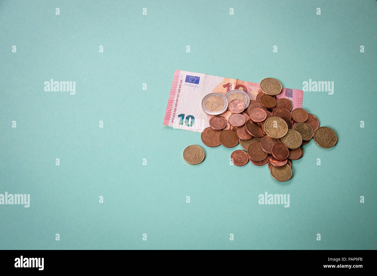 Dieci eur banconota con un piccolo cambiamento di monete su sfondo verde Foto Stock