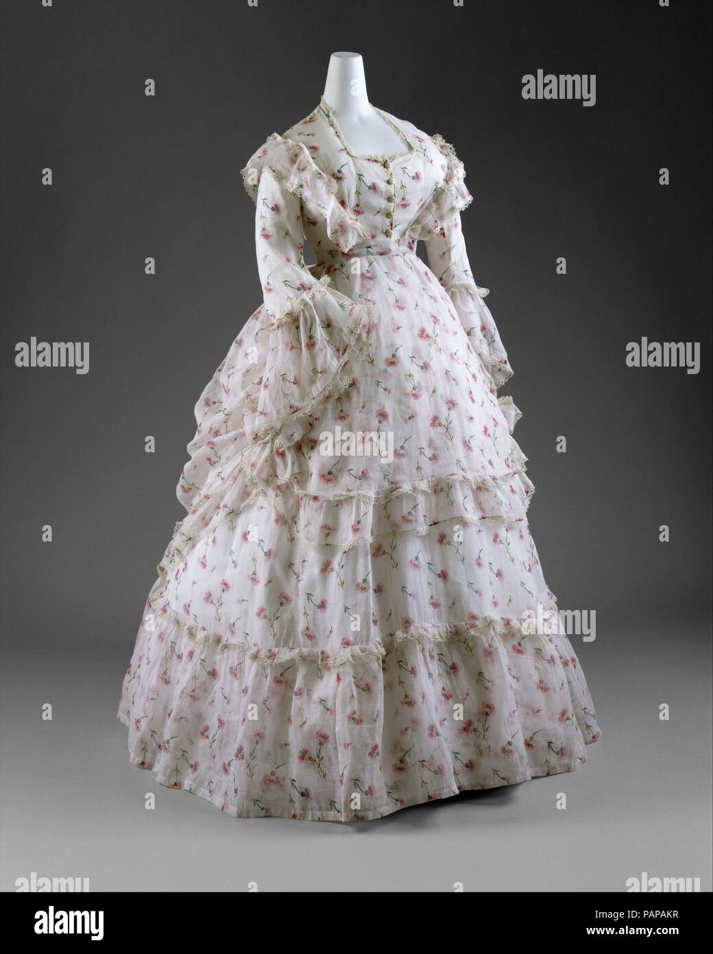 Abito. Cultura: francese. Data: ca. 1872. Il 1870 è stato un periodo di marcato romanticismo e un tocco di stravaganza in abiti alla moda. Molto simile al pittoresco dipinti di Renoir che illustrano tali creazioni dolciarie, sia di giorno che di sera abiti erano altamente ornati e spesso eseguita in delicati tessuti femminili. Sebbene eveningwear fu segnata dal décolleté scollature e sontuosa seta rasi e taffetas, abiti da giorno sono state rese più modesto con austera tessuti come il cotone o la lana. Mentre molte donne appartenenti a piedi e abiti da viaggio che dava leggermente maggiore moveability, anche piuttosto comune era il Foto Stock