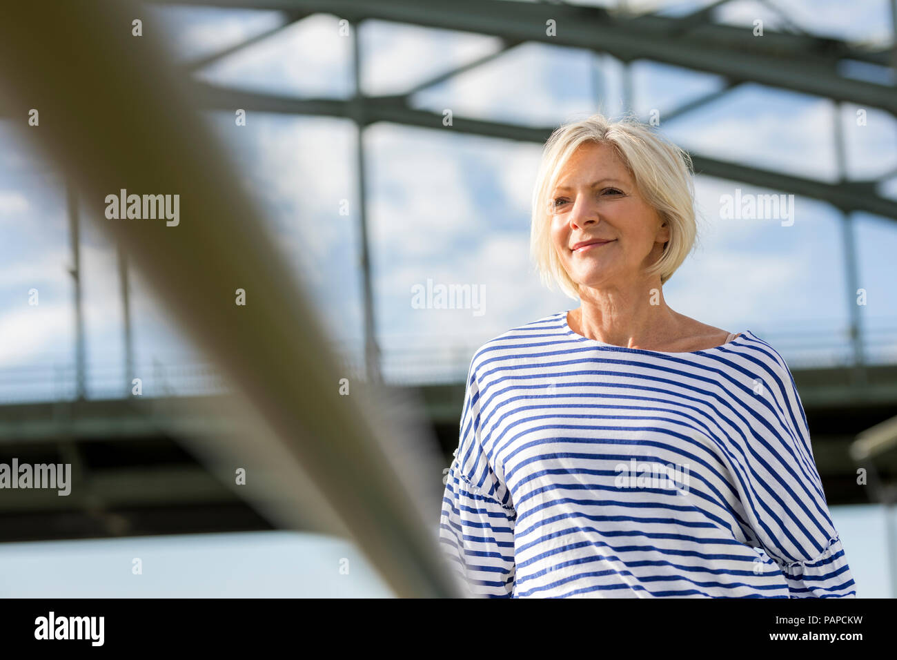 Ritratto di sorridente donna senior in corrispondenza di un ponte Foto Stock