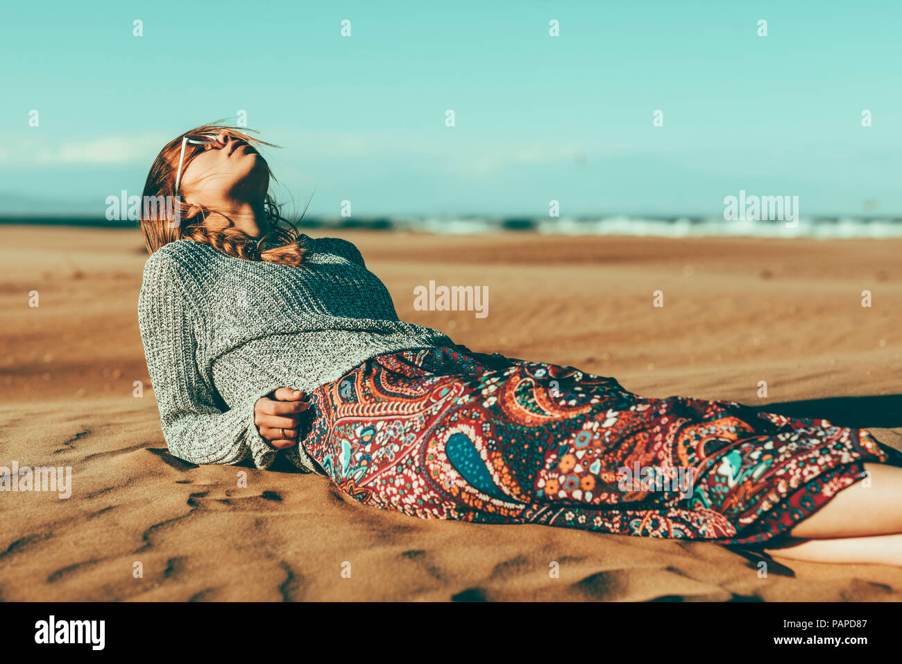 Giovane donna giaceva nel paesaggio del deserto Foto Stock