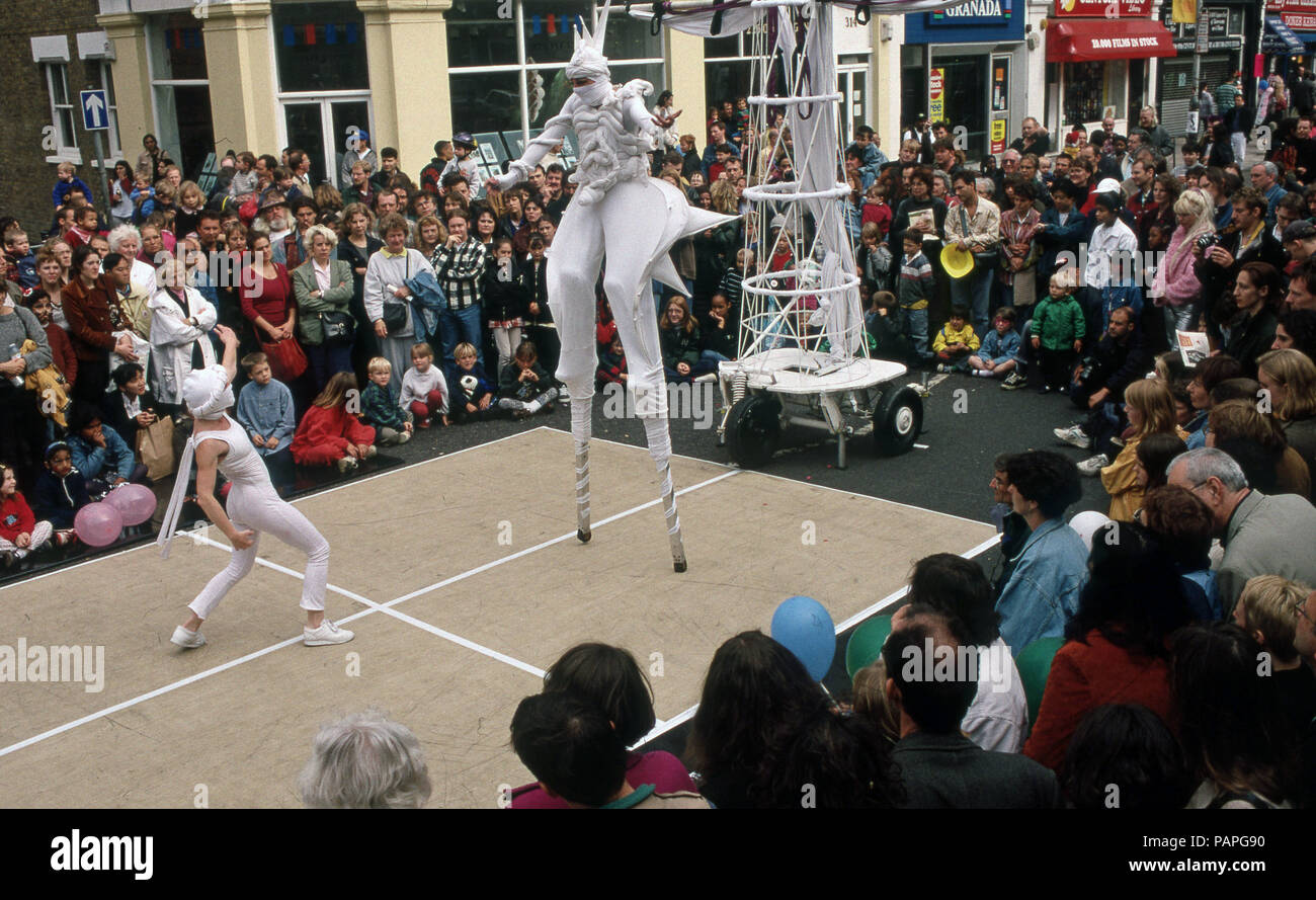 Street Festival di Walthamstow Londra con animatori camminando su palafitte Foto Stock