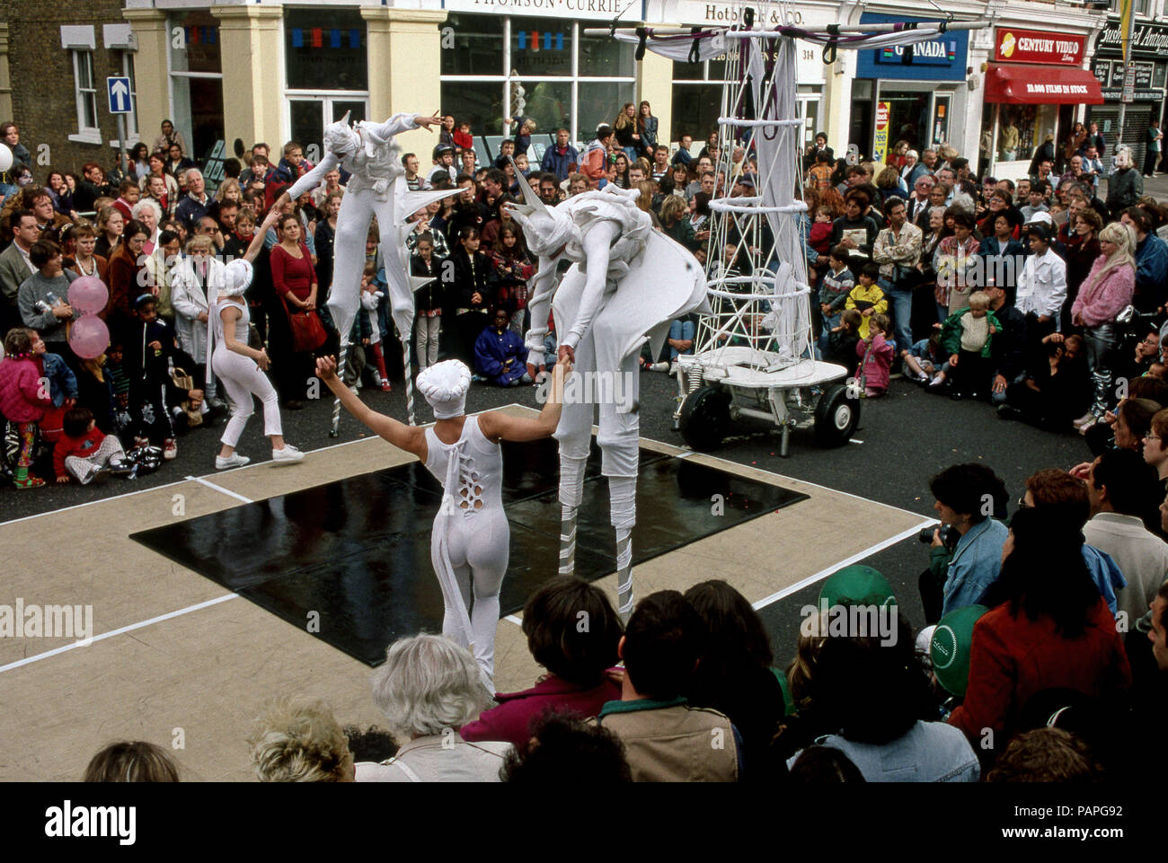 Street Festival di Walthamstow Londra con animatori camminando su palafitte Foto Stock