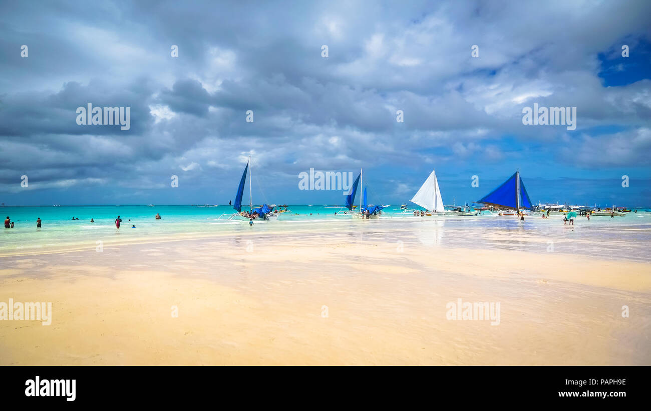 Barche a vela turistica fodera Boracay iconici spiaggia bianca e il mare turchese, con nubi sopra di raccolta - Aklan, Filippine Foto Stock