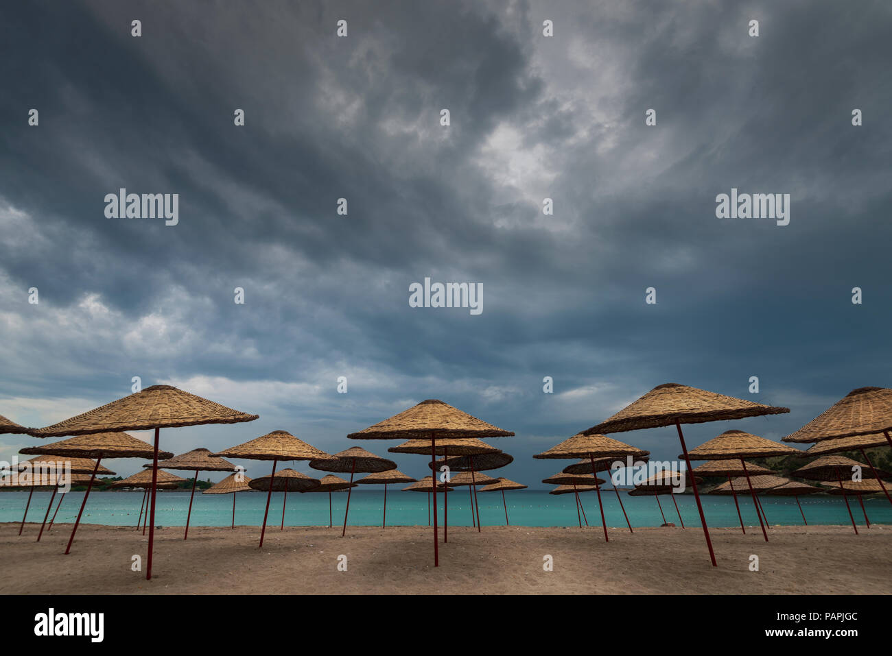 Ombrelloni da spiaggia e nuvole scure Foto Stock