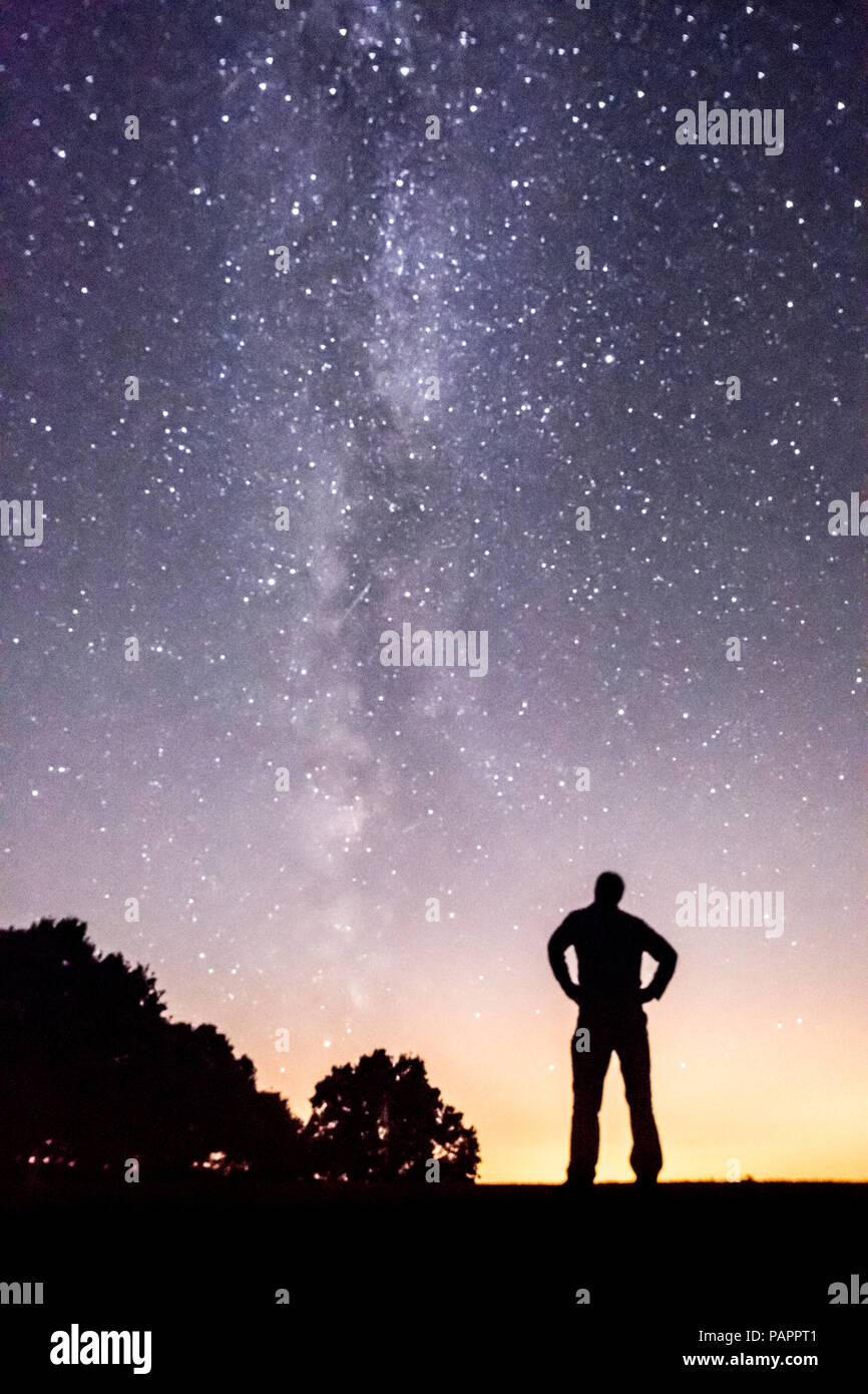 Uomo che sta guardando la Via Lattea si vede dal Sussex, Regno Unito, Luglio Foto Stock