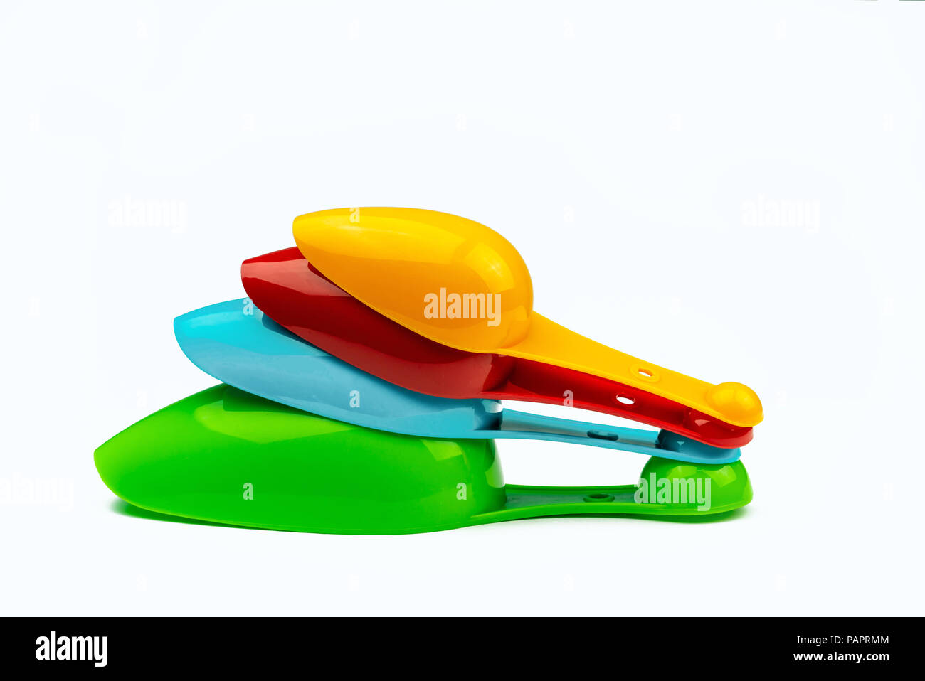 Set di plastica colorata misurino isolato su sfondo bianco con ombra. Verde, Blu, rosso e arancione in plastica cucchiaio di misurazione. Foto Stock