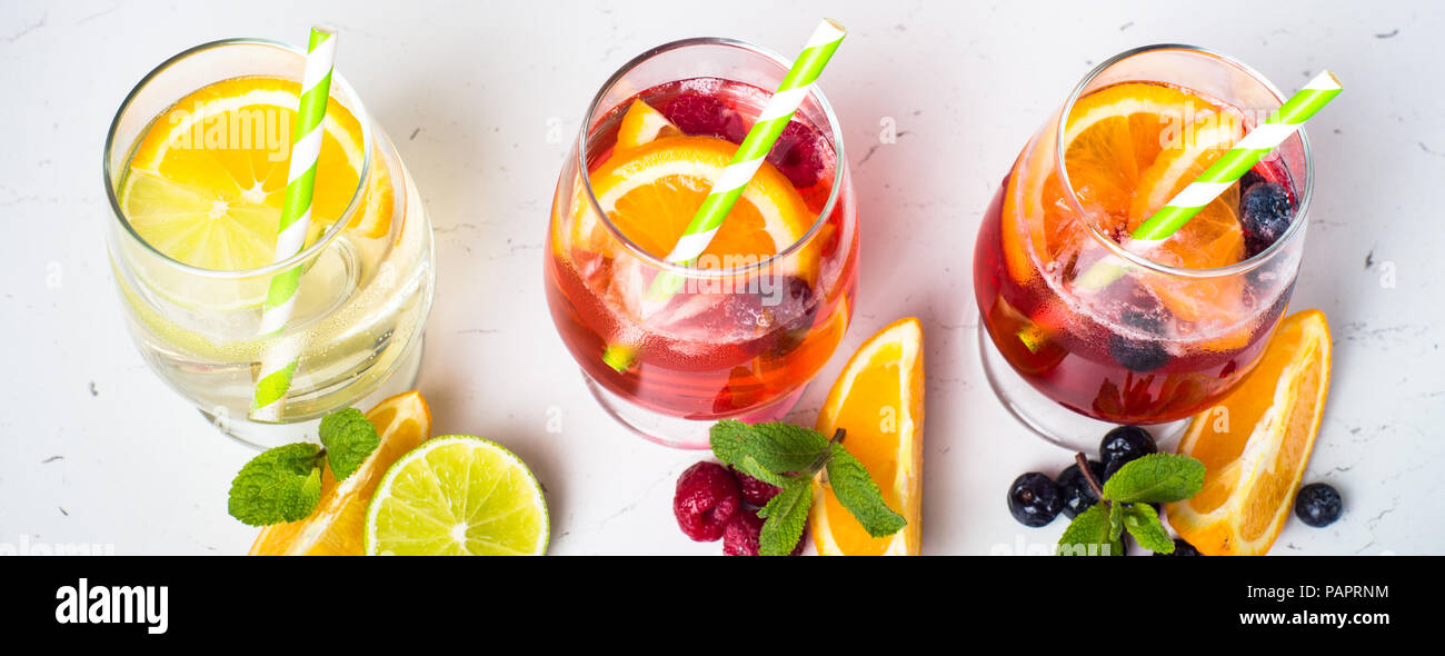 Bianco, rosa e rosso sangria con frutta e ghiaccio. Estate drink alcolici e gli ingredienti. Foto Stock