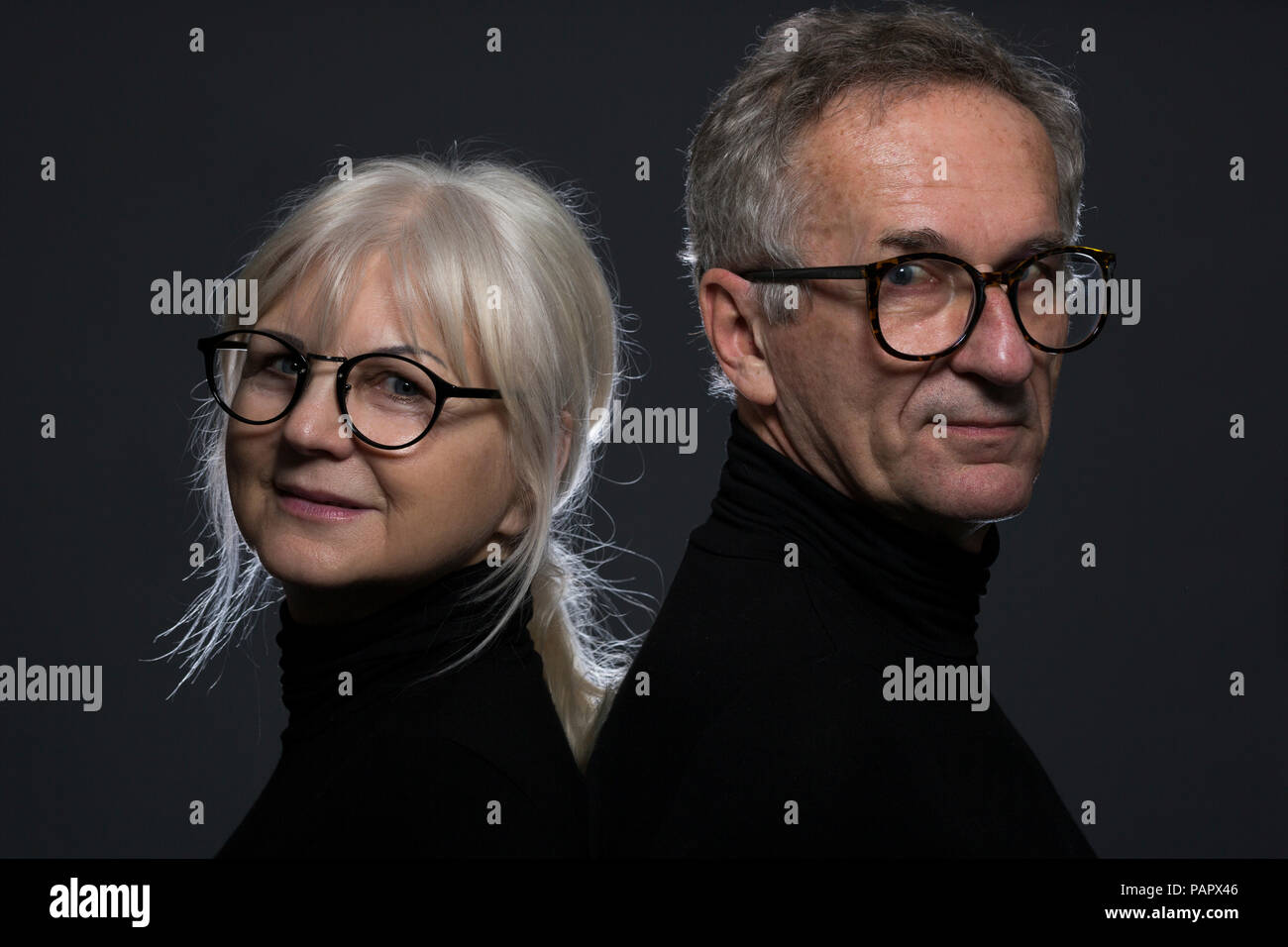 Ritratto di coppia senior con gli occhiali di fronte a uno sfondo scuro Foto Stock