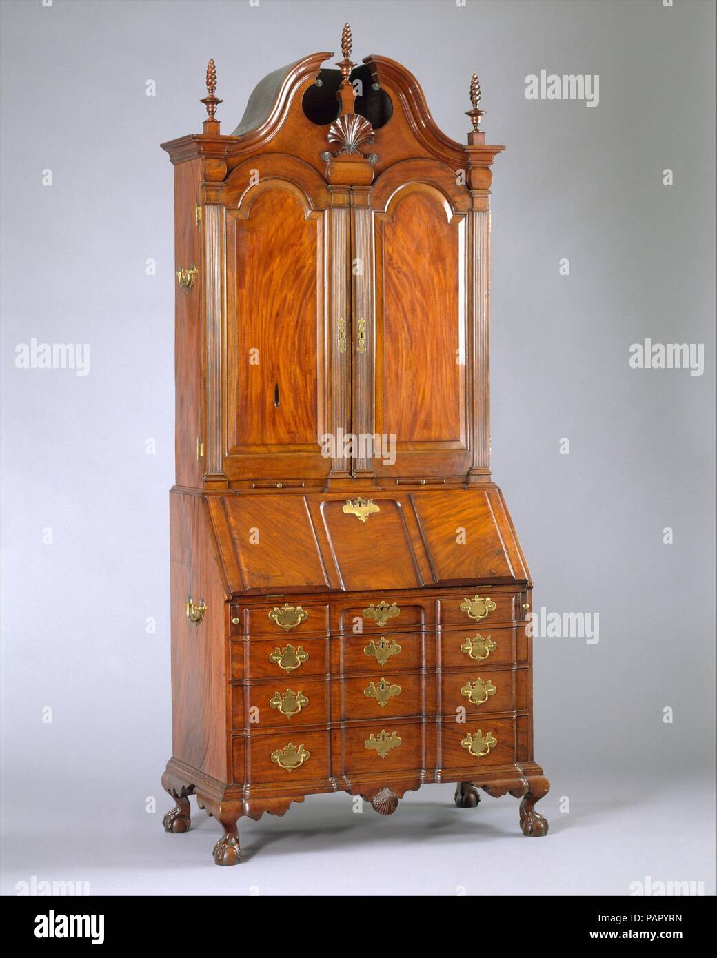 Scrivania e libreria. Cultura: American. Dimensioni: 105 x 45 x 24 in. (266.7 x 114,3 x 61 cm). Maker: Workshop di Nathaniel Gould (1734-1782). Data: ca. 1779. Questo alte e maestose segretario, modellato dei migliori mogano figurato, è un capolavoro dal negozio di Nathaniel Gould, il leader cabinetmaker di Salem, Massachusetts, nel terzo quarto del XVIII secolo. Quando Gould è morto nel 1781, egli è stato elencato come un gentleman, avente presumibilmente dato fino a lavorare con le sue mani. Su di una superficie interna, la scrivania e la libreria recare la enigmatica iscrizione: 'Nath Gould non è il suo lavoro.' Presumabl Foto Stock