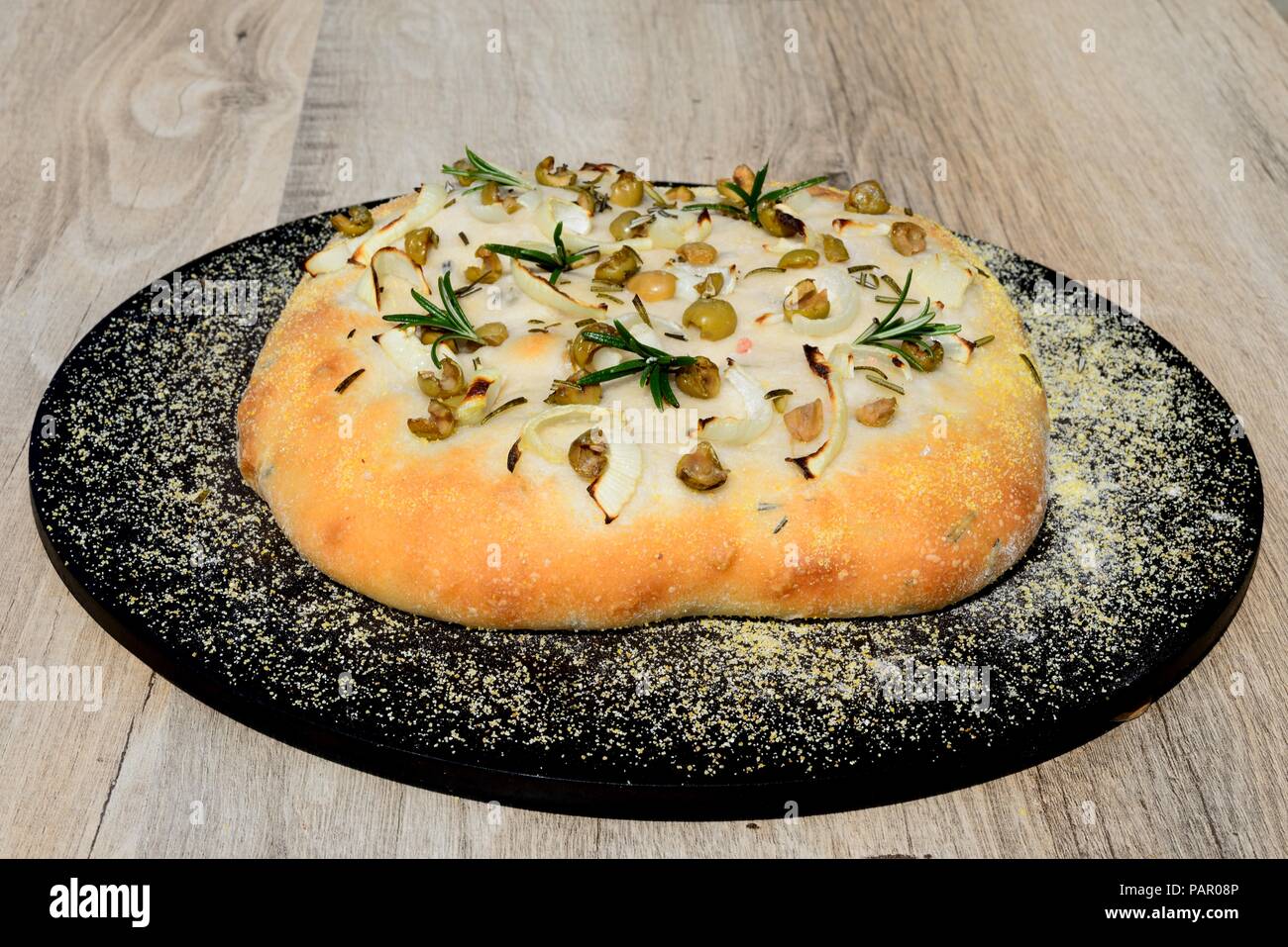 Casalingo italiano rosmarino, verde oliva e cipolla pane focaccia su una pietra di cottura, England, Regno Unito, Europa. Foto Stock