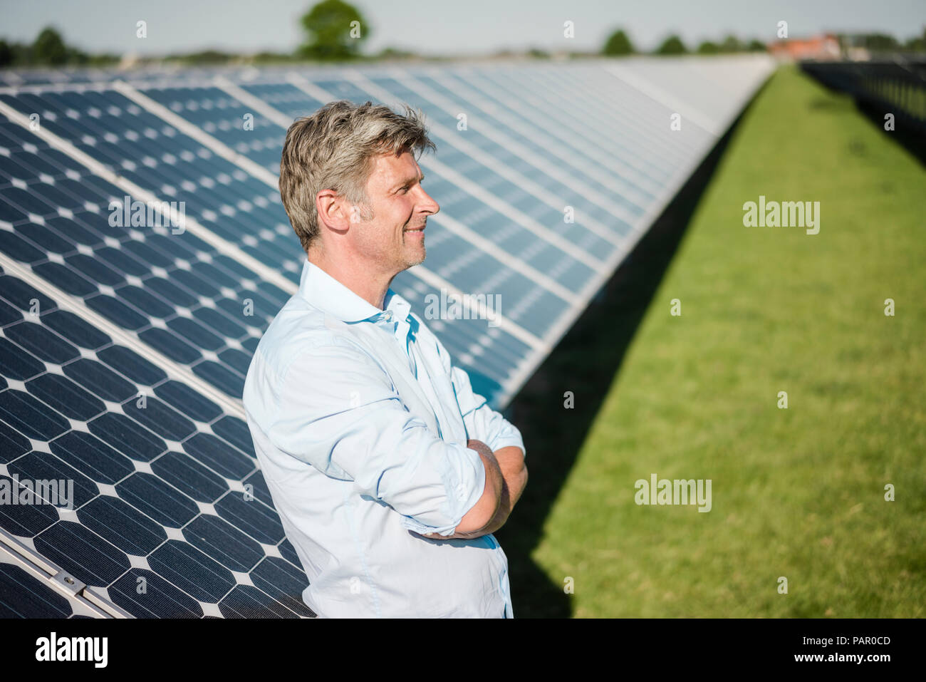 Sorridente uomo maturo in piedi in impianto solare Foto Stock