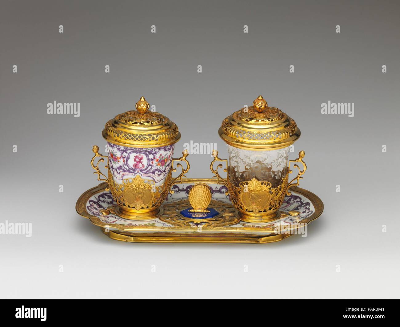 Ensemble per il cioccolato. Cultura: austriaca, a Vienna. Dimensioni: Vassoio (conferma): 8 1/2 x 5 3/8 x 3/4 in. (21,6 x 13,7 x 1,9 cm); becher di porcellana (conferma): 2 11/16 x 2 5/8 x 2 5/8 in. (6,8 x 6,7 x 6,7 cm); bicchiere di vetro con coperchio: 4 1/4a. (10,8 cm); altezza montato il vassoio, bicchiere, coperchio (conferma): 4 7/8 in. (12,4 cm). Factory: Vienna. Il direttore di fabbrica: Du Paquier periodo (1718-1744). Data: 1735-40. Questo ensemble mostra la stretta collaborazione tra Du Paquier e orafi Viennese. La decorazione pittorica telai l'oro monta e la classica capi sulla gold trembleuse gallerie Foto Stock