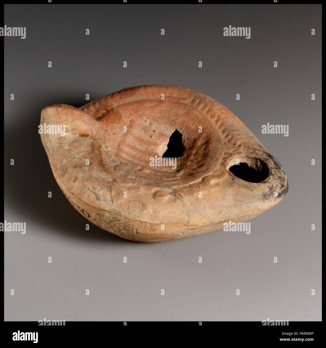 Olio di terracotta con lampada. Cultura: romana, cipriota. Dimensioni: complessivo: 1 1/4 x 3 1/8 in. (3,2 x 7,9 cm). Data: 4th-5secolo D.C.. Vessberg tipo 18. Maniglia non forato. Stampo-fatta. Discus: bestiarius utilizzando grandi coclea per lo schermo da un orso; lettere in rilievo sotto la coclea. Spalla: lato destro, a lisca di pesce corona; lato sinistro, lupo (?) in esecuzione verso l uomo con i bracci sollevati. Sulla base, cerchio di sollevato lettere greche. Foro di riempimento leggermente danneggiato al lato destro. Museo: Metropolitan Museum of Art di New York, Stati Uniti d'America. Foto Stock