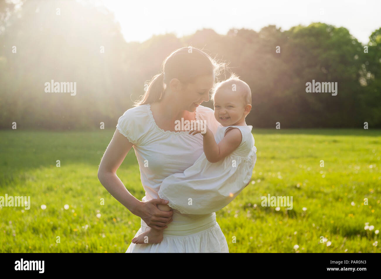 Madre e figlia giocando sul prato in estate Foto Stock