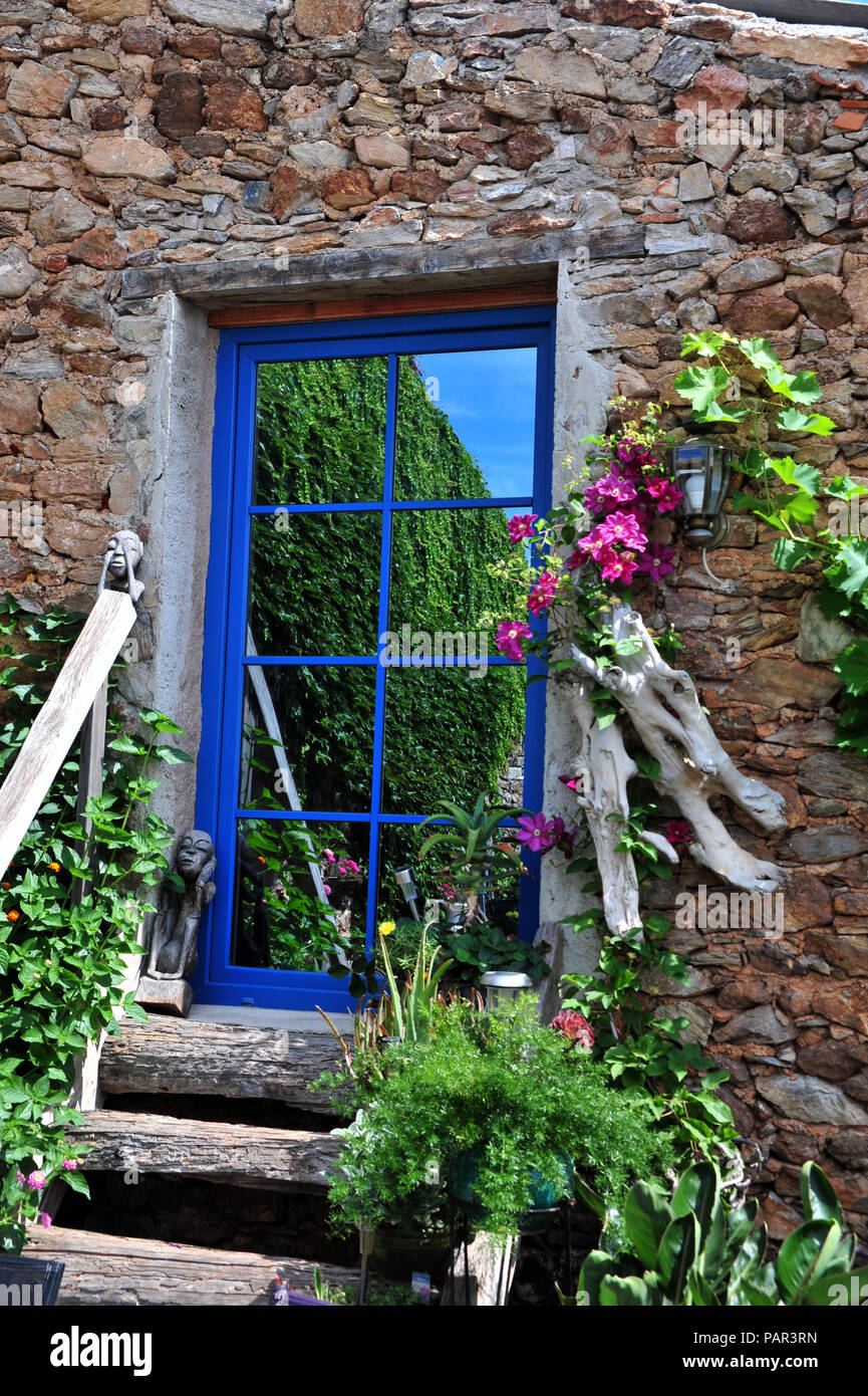 Stravagante porta speculare alla sommità di gradini in legno in un meraviglioso giardino nel sud della Francia. Proprietà rilasciato Foto Stock