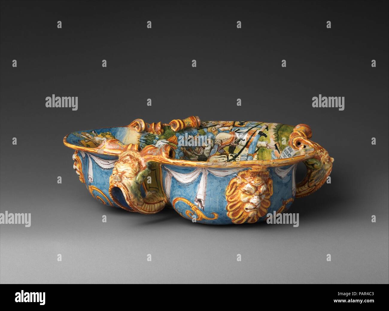 Wine Cooler con Carlo V la vittoria di Mühlberg. Artista: sulla base di una incisione da Enea Vico (italiano, Parma 1523-1567 Ferrara); probabilmente dopo un progetto di Battista Franco (italiano, Venezia ca. 1510-1561 Venezia). La cultura italiana, Urbino. Dimensioni: complessiva (conferma): 5 7/8 × 19 1/2 × 19 1/2 in. (14,9 × 49,5 × 49,5 cm). Data: ca. 1560-90. Il dipinto di scena all'interno di questo scambiatore di calore rappresenta un importante sedicesimo secolo evento--il 1547 la vittoria delle forze cattoliche del Sacro Romano Imperatore Carlo V oltre i suoi nemici protestanti. Una iscrizione latina identifica la scena che è stata adap Foto Stock