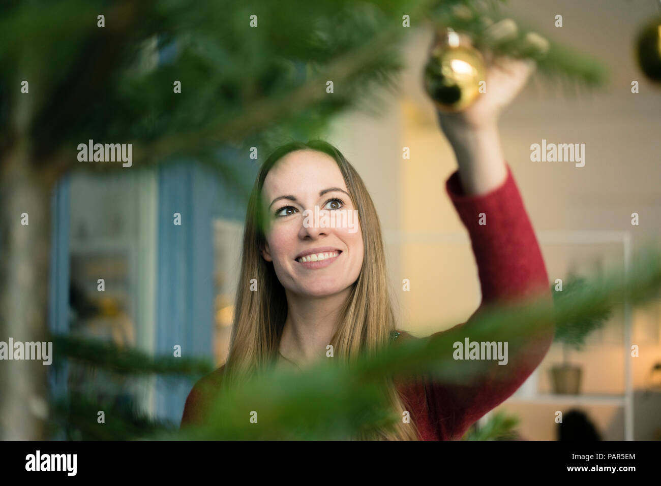 Ritratto di donna sorridente decorare albero di Natale Foto Stock