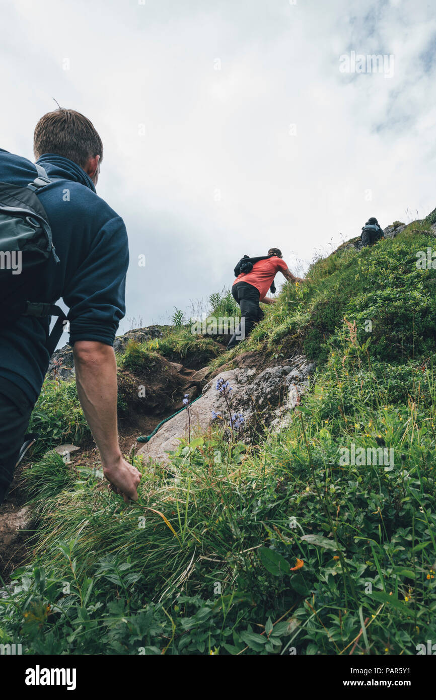 Norvegia Lofoten, Moskenesoy, giovani uomini climing il Hermannsdalstinden Foto Stock