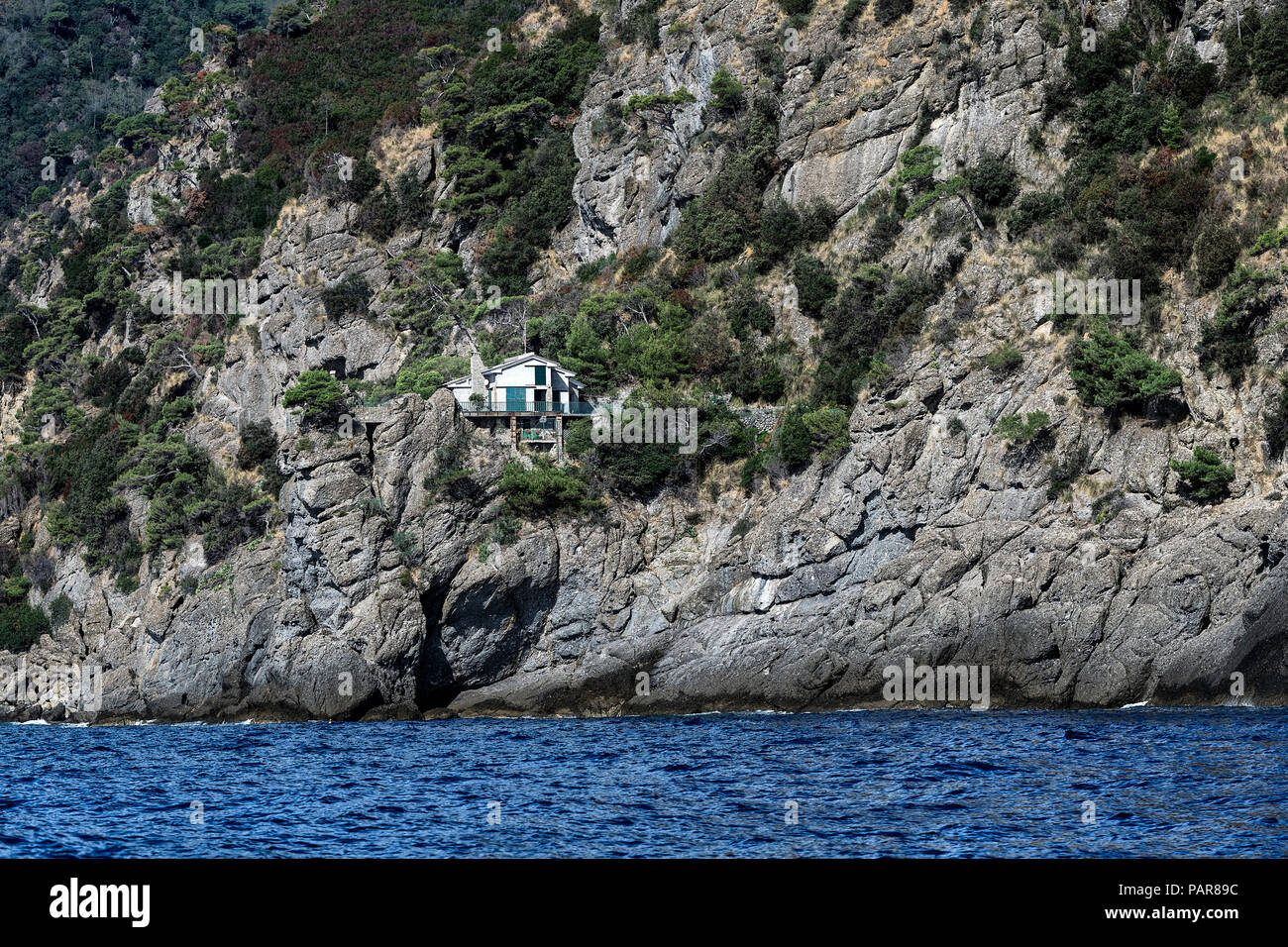 Unica casa impostata nelle ripide scogliere ligure, Italia. Foto Stock