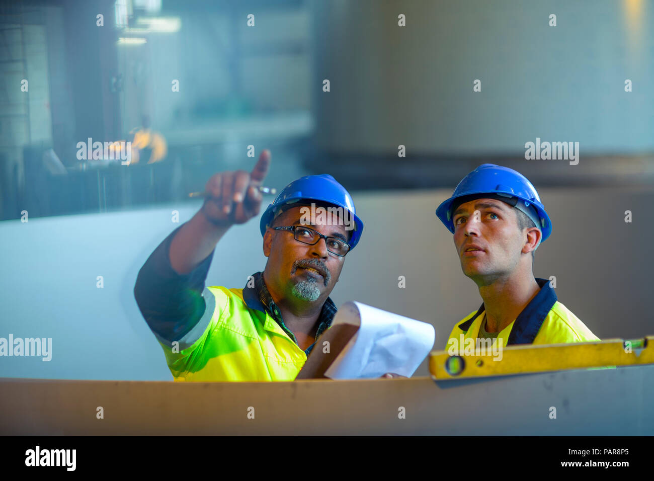 Gli ingegneri in impianti industriali per discutere il lavoro Foto Stock