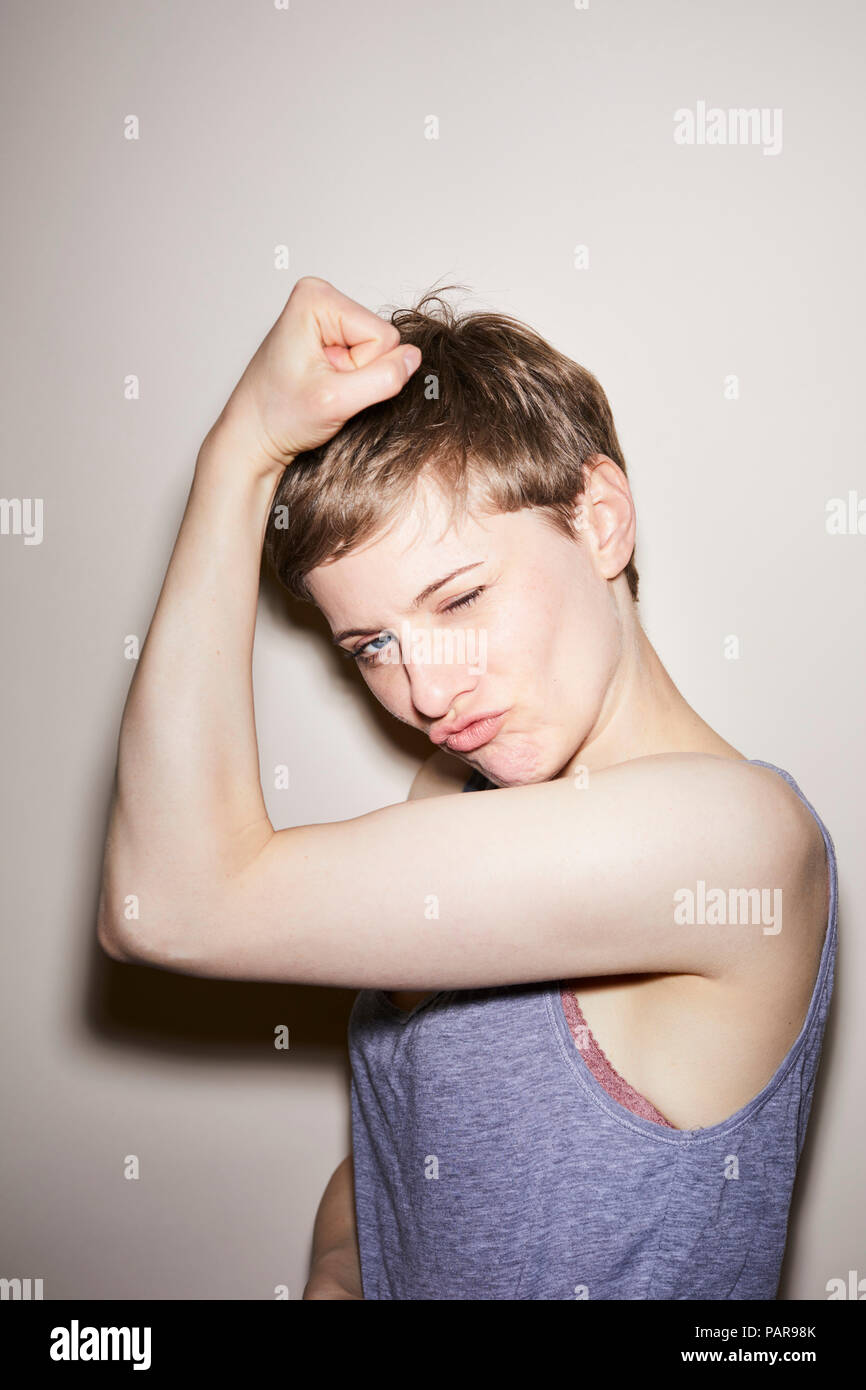 Ritratto di donna bionda, capelli corti, che mostra i muscoli Foto Stock