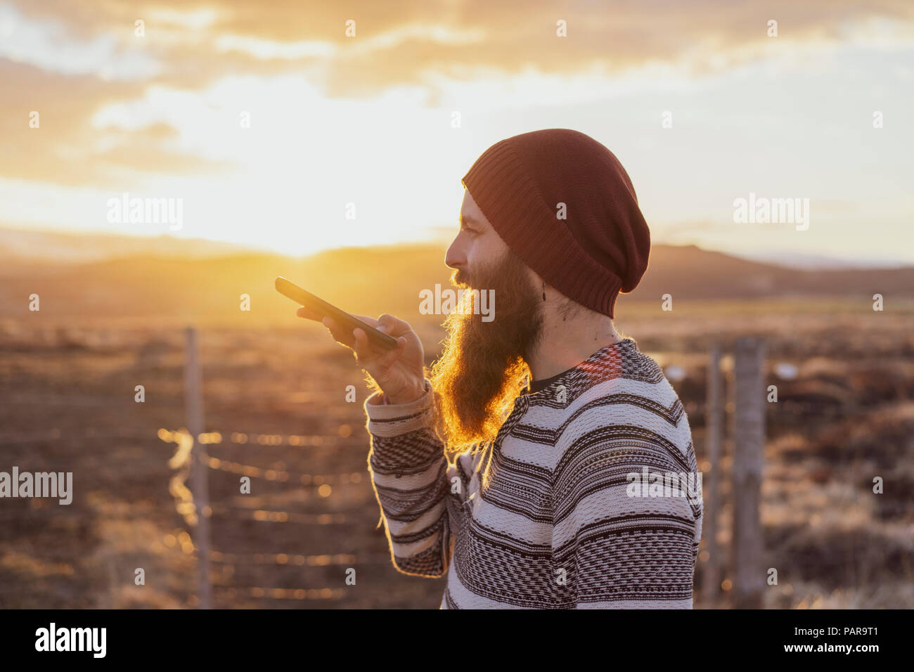 L'Islanda, il giovane uomo utilizza lo smartphone, messaggio vocale Foto Stock