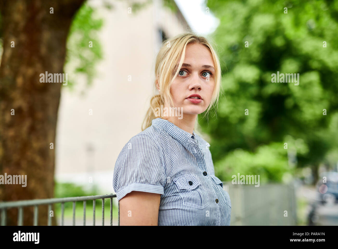 Grave giovane donna bionda in un recinto Foto Stock