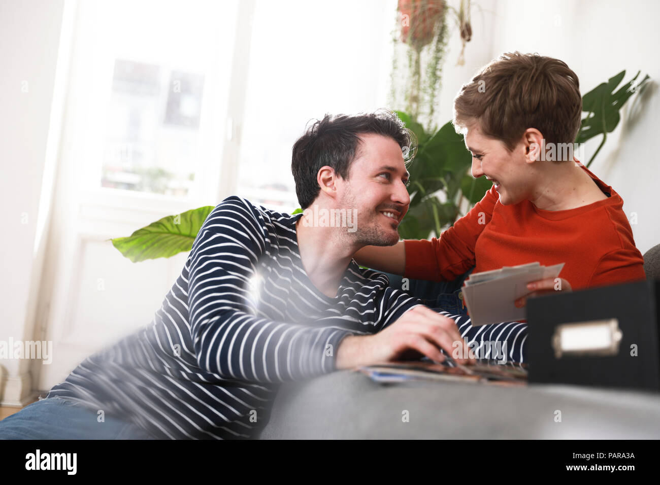 Giovane seduto a casa , guardando le vecchie fotografie Foto Stock