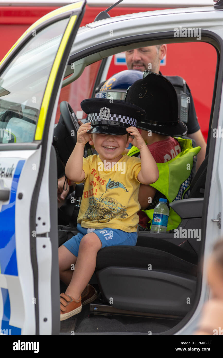 Ragazzo con un sovradimensionamento del poliziotto hat in un paese di lingua inglese fair. Foto Stock