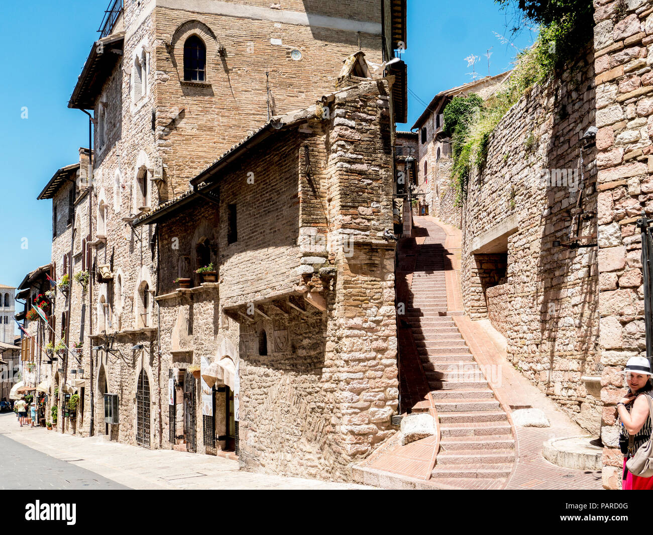 Le fasi e i negozi sulla incantevole borgo medievale Via Frate Elia nella città vecchia, Assisi, Umbria, Italia Foto Stock