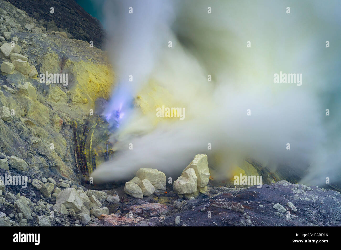 Blu fiamme di zolfo e fumi di zolfo dal cratere di Kawah Ijen Volcano in Indonesia. Foto Stock