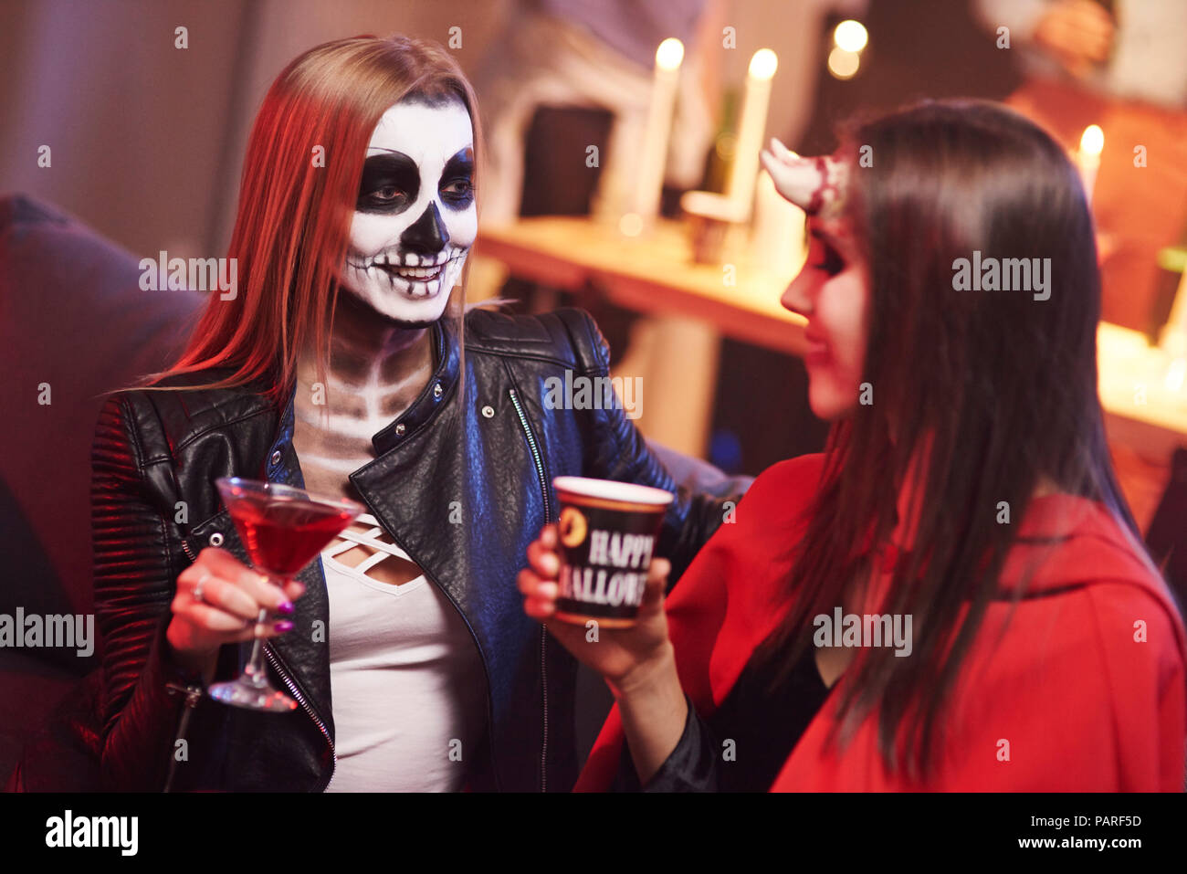 Donne in costume raccapricciante di bere a parte Foto Stock