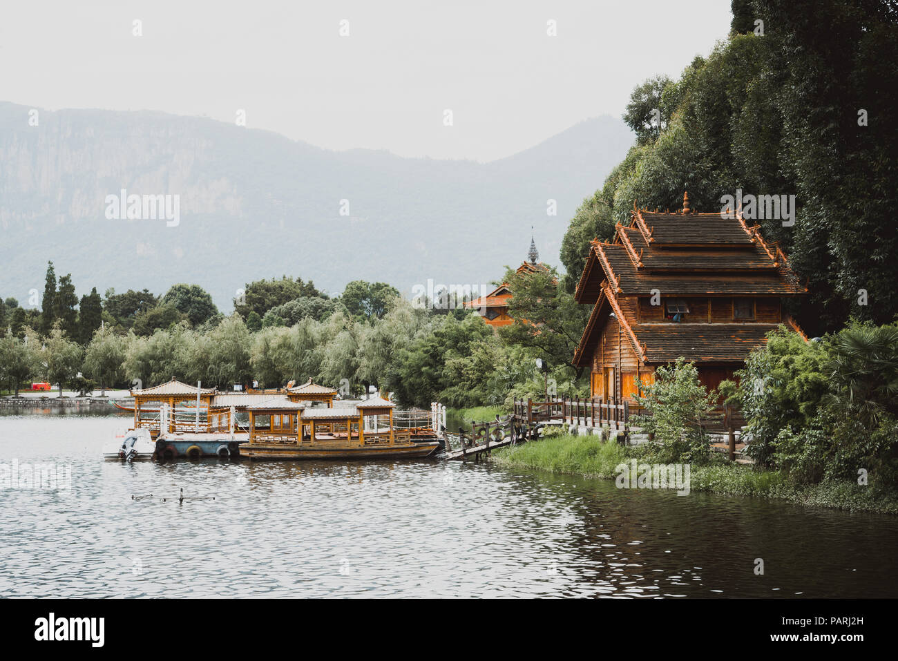 Tradizionalmente casa costruita da un lago e barche in Yunnan nazionalità villaggio in Kunming, in Cina Foto Stock