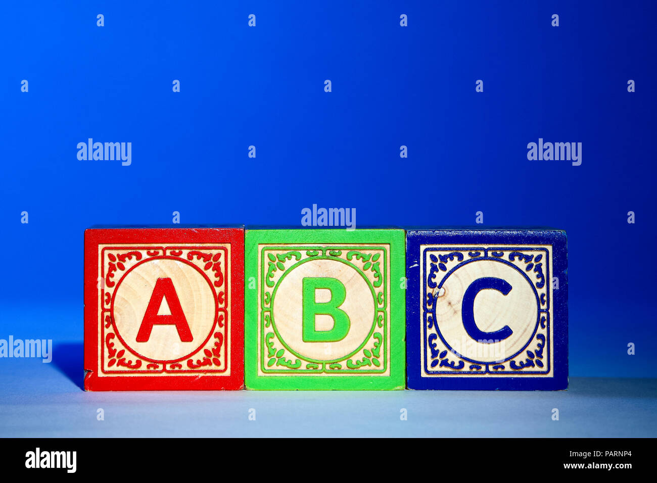 Lettera in legno blocchi su uno sfondo blu con le lettere abc Foto Stock