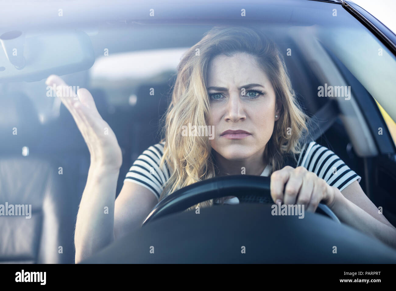 Arrabbiato donna alla guida di un'auto. Foto Stock