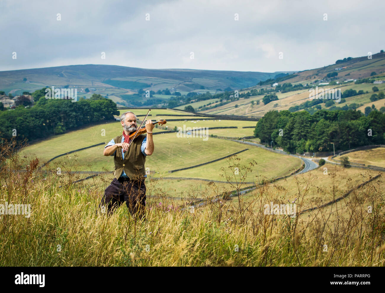 Violino artigiano Steve Burnett pone al mori sopra Haworth con la sua handcrafted Emily Bronte violino in vista del bicentenario del writer che cade il 30 luglio. Il violino artigianale è realizzato dal legno di un vecchio sicomoro che sorgeva nel villaggio di Haworth dove Bronte ha vissuto e scritto. Foto Stock