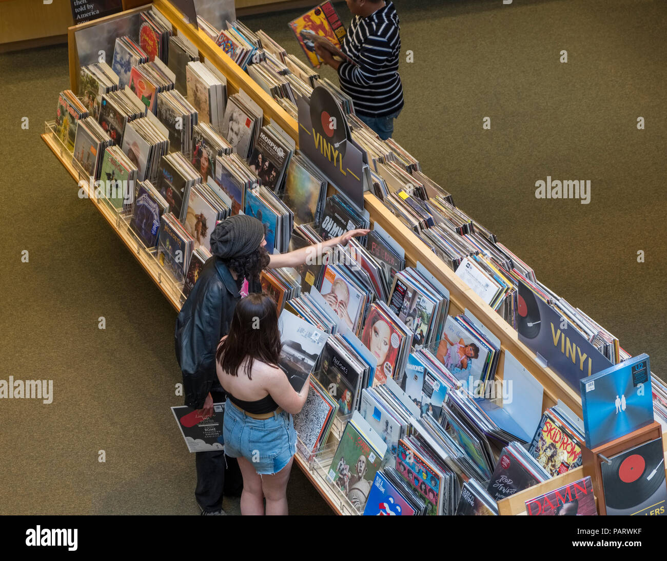 Navigazione persone dischi in vinile e gli album in rack a un record shop interno dello store di Los Angeles, la California, Stati Uniti d'America Foto Stock