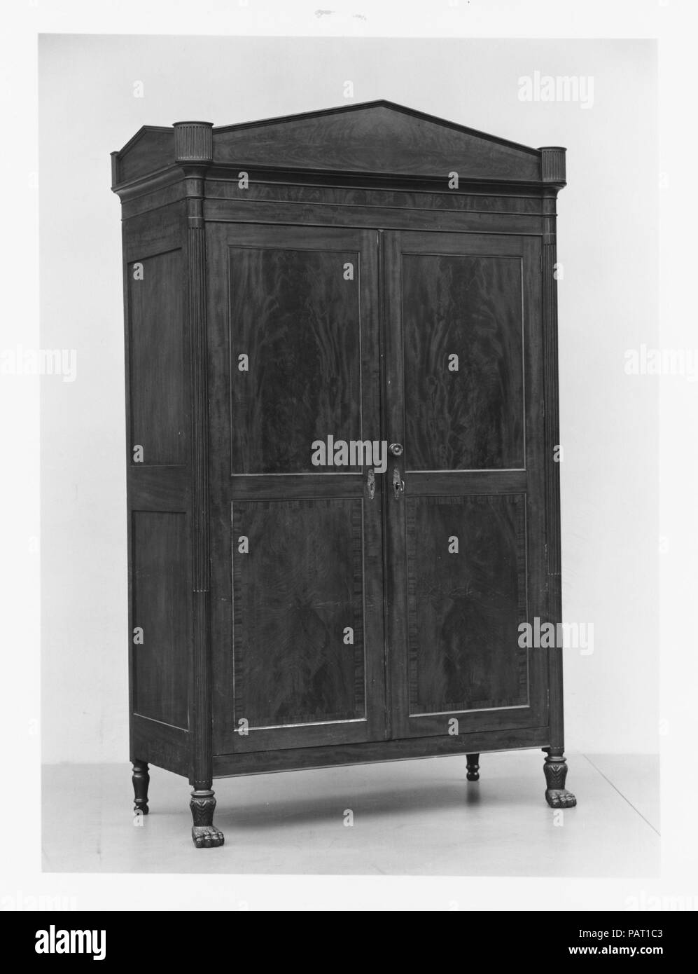 French press. Cultura: American. Dimensioni: 93 x 58 x 26 1/2 in. (236.2 x 147,3 x 67,3 cm). Data: 1810-15. Sebbene sia simile a un inglese un guardaroba, questa forma specifica è chiamato un "French press" nella città di New York libro di prezzi per cabinetwork di 1810, una pubblicazione che impostare il salario per l'artigiano furniture makers. Dietro il splendidamente porte impiallacciate sono due serie di tre vassoi scorrevoli separate da due livelli di cassetti. In contrasto, un armadio è stato suddiviso in una sezione superiore con antine e una sezione inferiore con tre cassetti. Museo: Metropolitan Museum of Art di New York, Stati Uniti d'America. Foto Stock