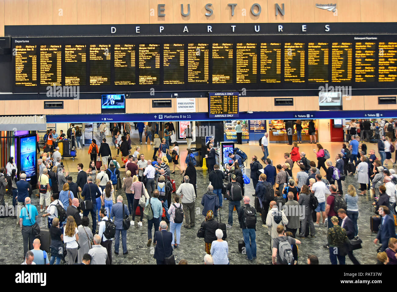 Vista da sopra guardando giù all interno della stazione dei treni di Euston concourse con passeggeri visualizzazione treno partenze Informazioni di viaggio Londra REGNO UNITO Foto Stock