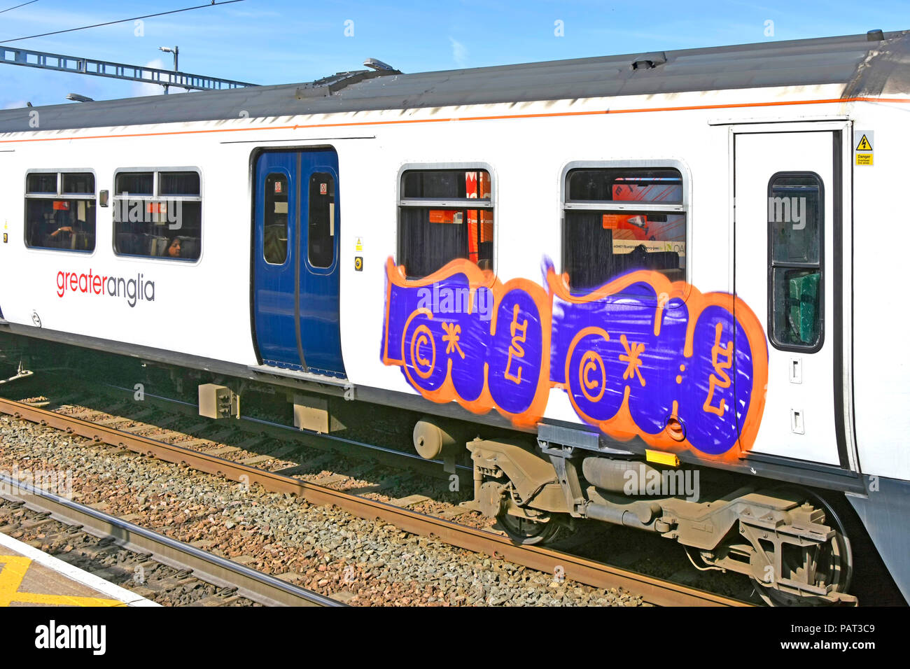 Trasporto danni criminali di maggiore Anglia treno & carrozza ferroviaria finestrino di portiera attraverso graffiti si aggiunge al costo del trasporto pubblico di Londra REGNO UNITO Foto Stock