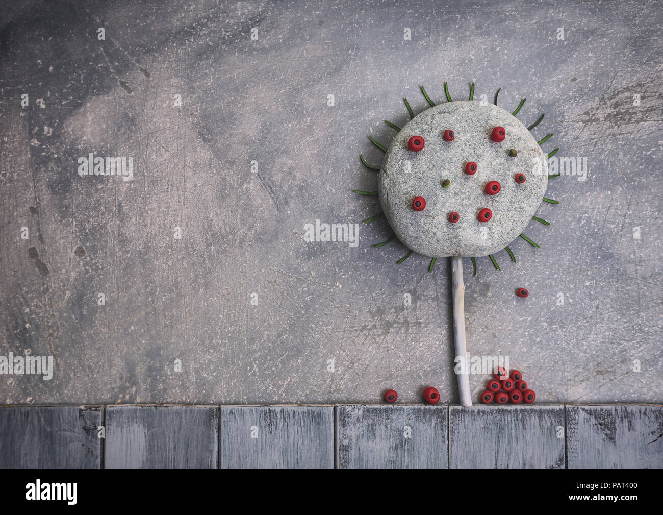 Creative paesaggio autunnale composizione fatta di pietra e di bacche rosse posati sul grigio Sfondo graffiante Foto Stock