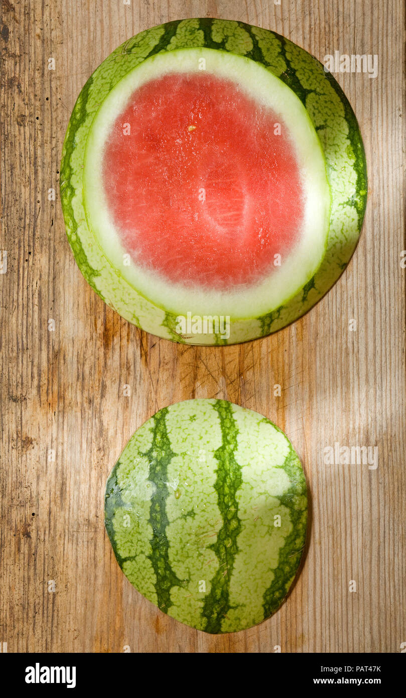 Top cut off anguria fresca su uno sfondo di legno Foto Stock