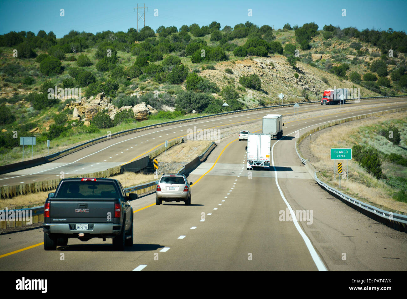 In viaggio in auto sulla route 66 autostrada con auto e camion provenienti in giro nei pressi di Blanco Creek nel nuovo paesaggio messicano Foto Stock