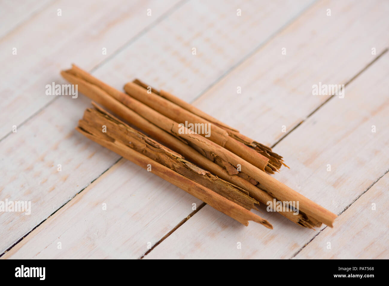 Bastoncini di cannella su un bianco tavolo di legno come un macro orizzontale shot Foto Stock
