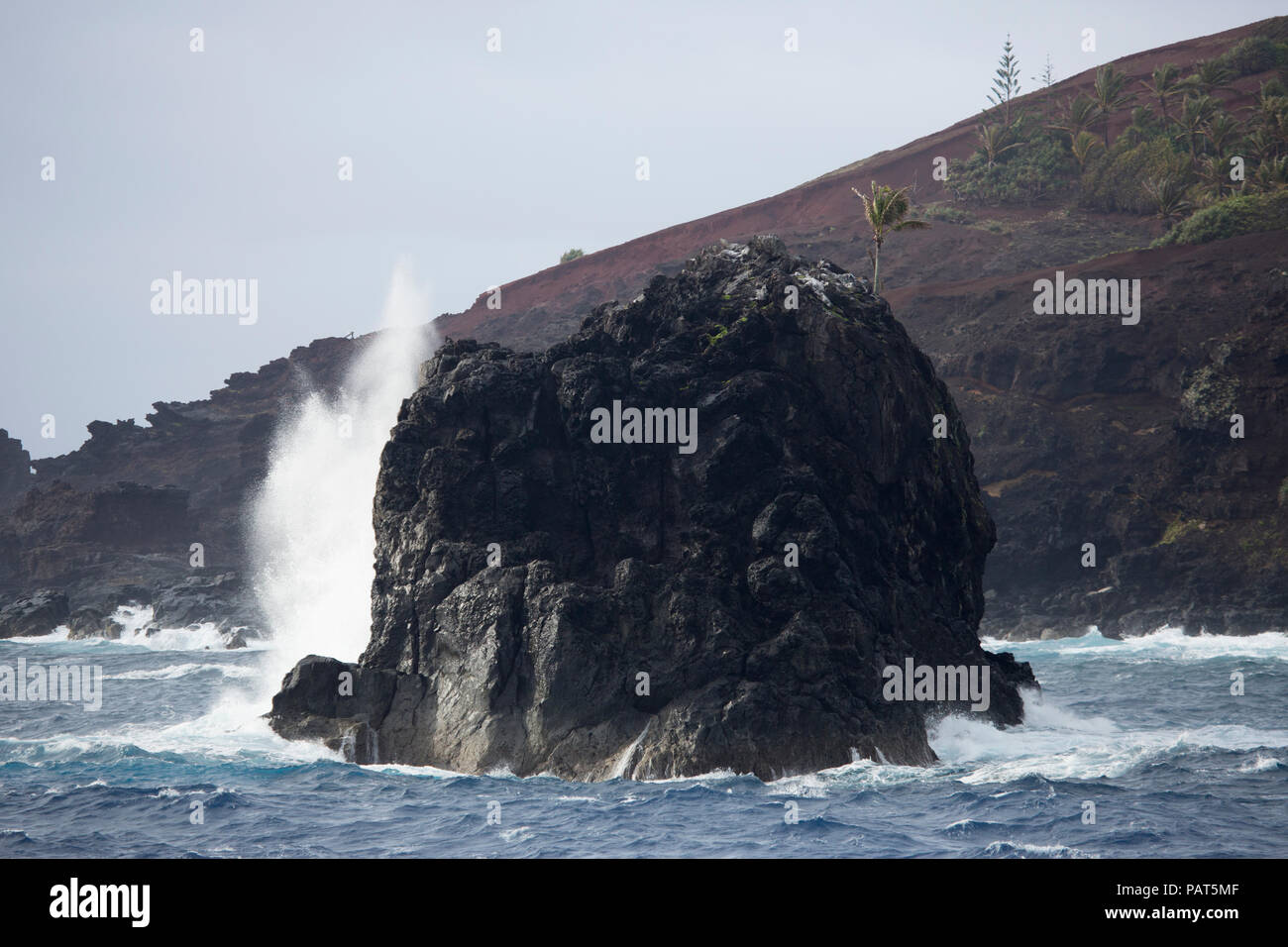 Bounty Bay, Isole Pitcairn, onde si infrangono in una roccia offshore Foto Stock