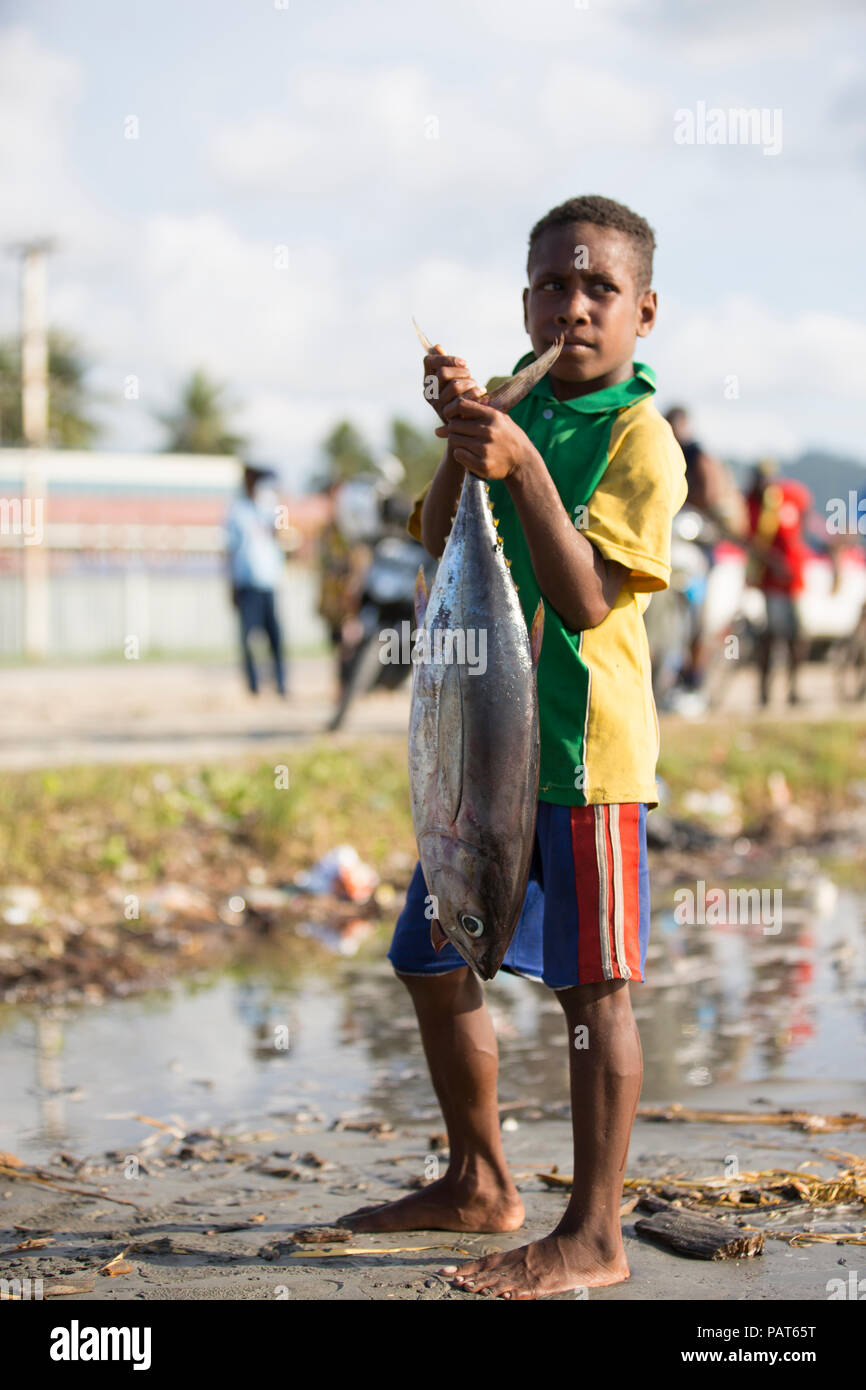 Papua Nuova Guinea, Vanimo, giovane ragazzo nel villaggio, con pesci di grandi dimensioni. Foto Stock
