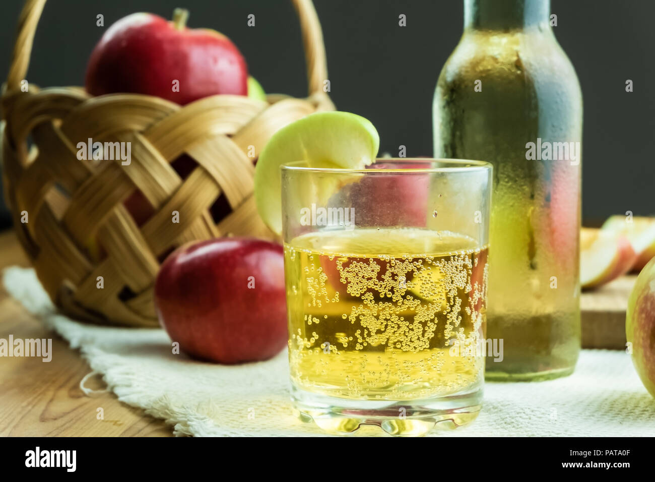 Close-up immagine del sidro spumeggiante bevanda e mature mele succose su tavola in legno rustico. Bicchiere di fatto in casa e sidro coltivati localmente mele biologiche Foto Stock