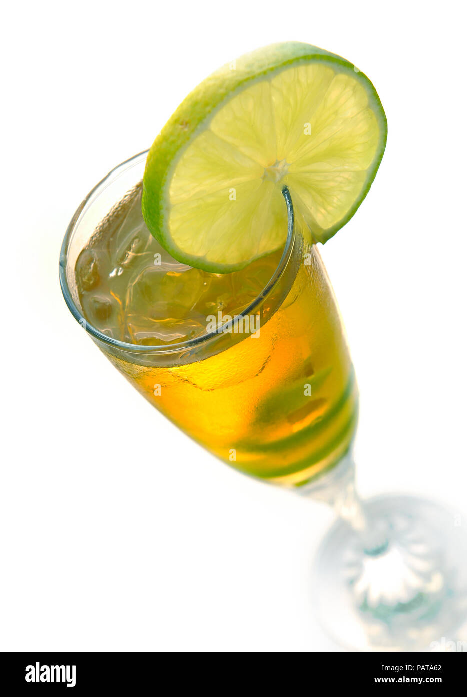 Cocktail giallo in vetro con calce twist su un bianco Foto Stock