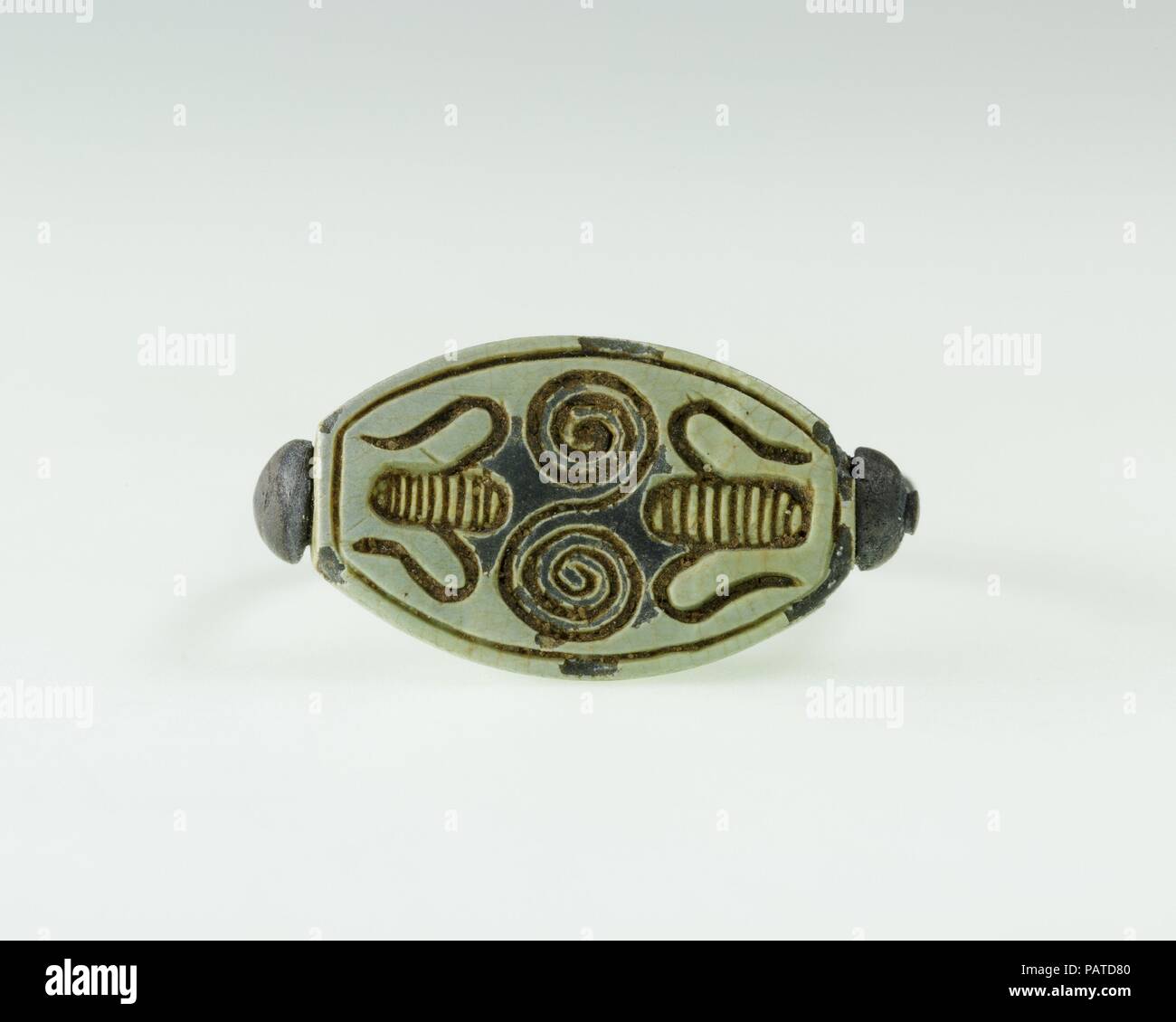 Anello di Hatnefer. Dimensioni: Anello: H. 2,3 cm (7/8 in.); W. 2.1 cm (13/16 in.) Cowroid: L. 1.7 cm (11/16 in.); wW 1,2 cm (1/2 in.); H. 0,7 cm (1/4 in.). Dynasty: Dynasty 18, presto. Regno: regno di Thutmosi II-inizio comune di regnare. Data: ca. 1492-1473 A.C. Questo anello è stato trovato sul dito medio di Hatnefer la mano sinistra. Esso è stato impostato con un amuleto conformata a guscio cowrie ed inscritto sulla base di un modello geometrico che assomigliano vagamente a una lucertola. Gli anelli e i piccoli scarabei trovato su Hatnefer della mummia (36.3.3-.6) erano gioielli personali, non fa parte del suo i corredi funerari. Museo: Metrop Foto Stock