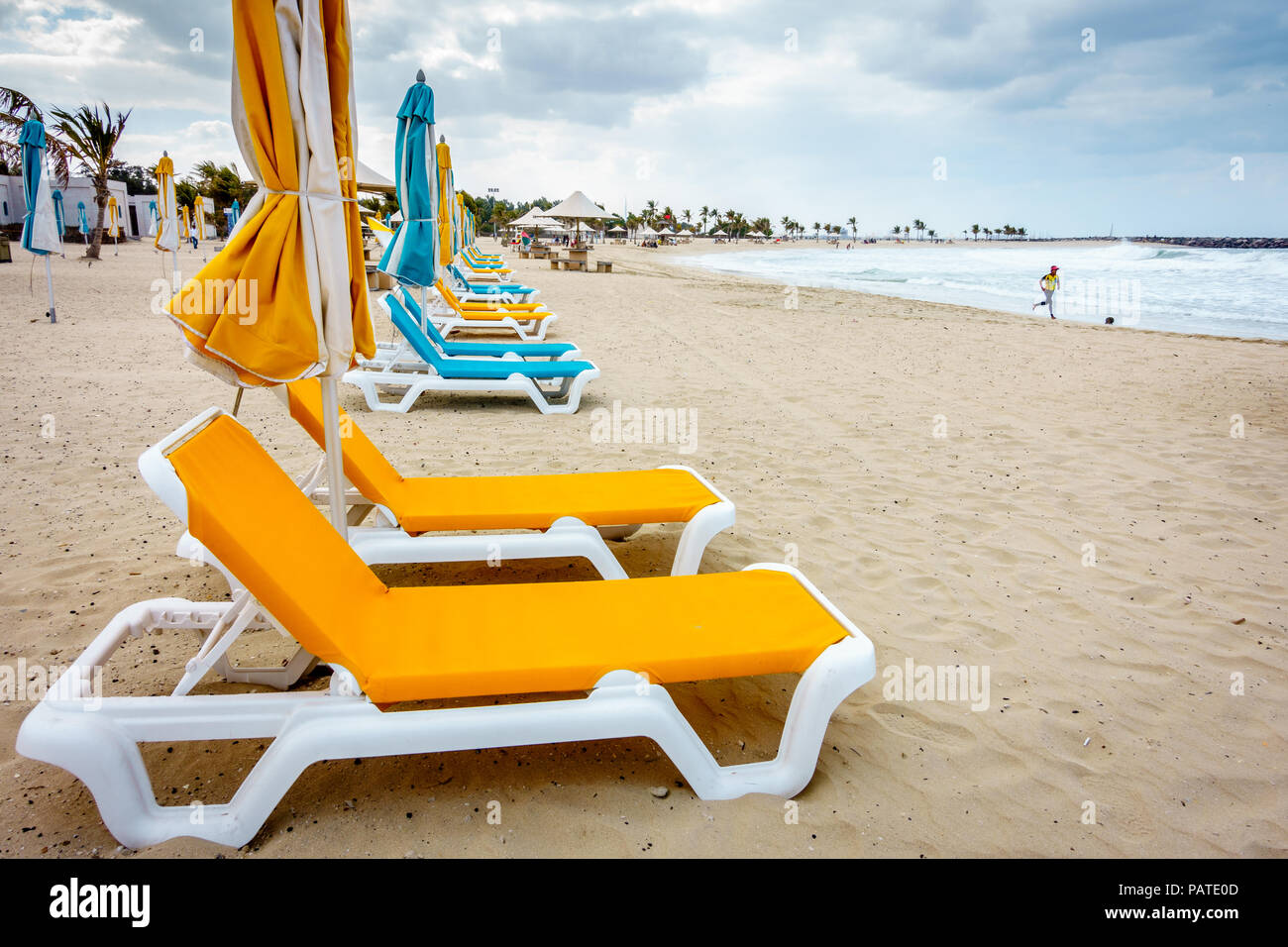 Uomo che corre sulla spiaggia al Parco Al Mamzar Beach Park a Dubai, Emirati arabi uniti Foto Stock
